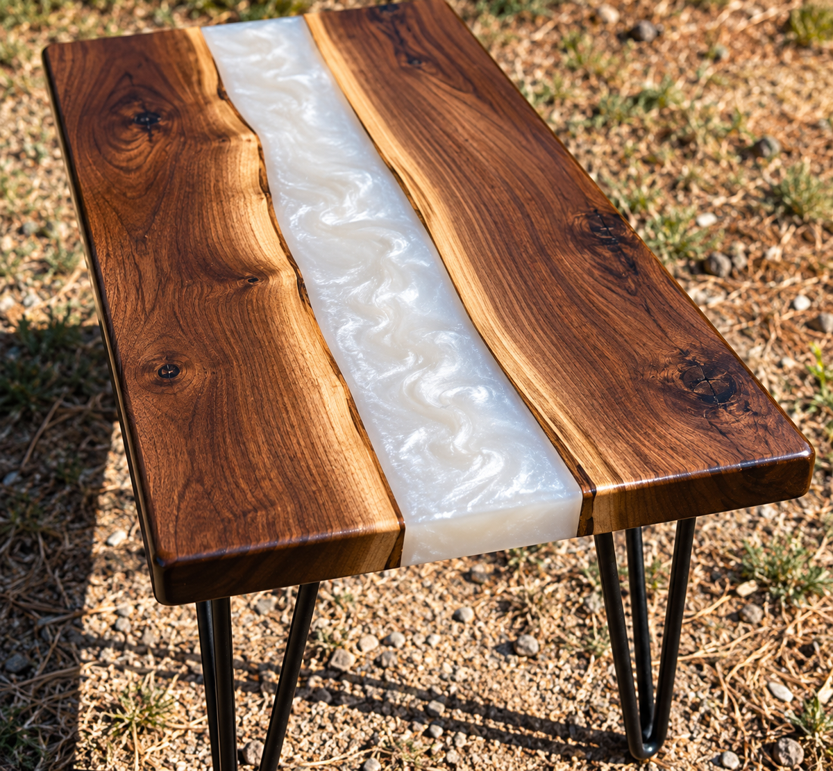 Handmade walnut epoxy river accent table with swirling pearl-white resin center, natural walnut wood grain, and black metal hairpin legs. 